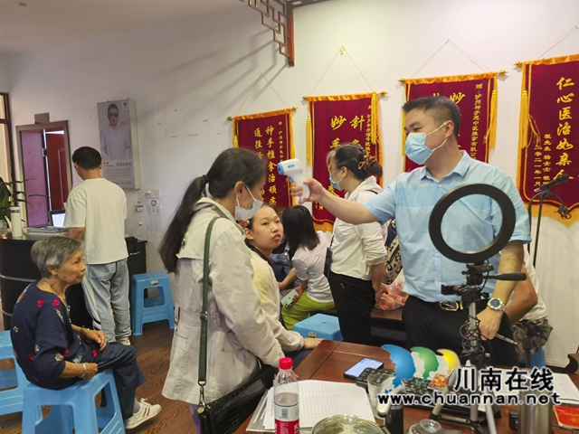 残联工作人员为参会人员测体温.jpg