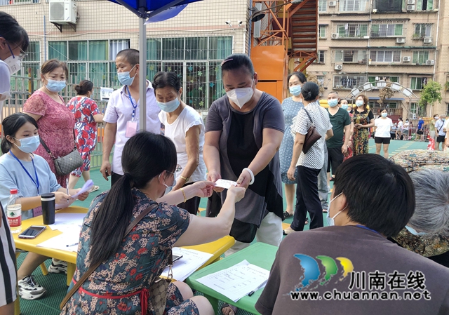 龙马潭区防疫志愿者王文莲:“我是一块砖,哪里需要我,我就顶上去!”(图4) 王文莲正在发放小区居民出入卡.jpg