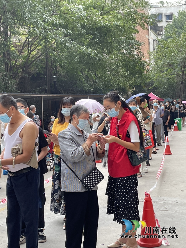 志愿者简国勤（穿红马甲）帮助老人做核酸.jpg
