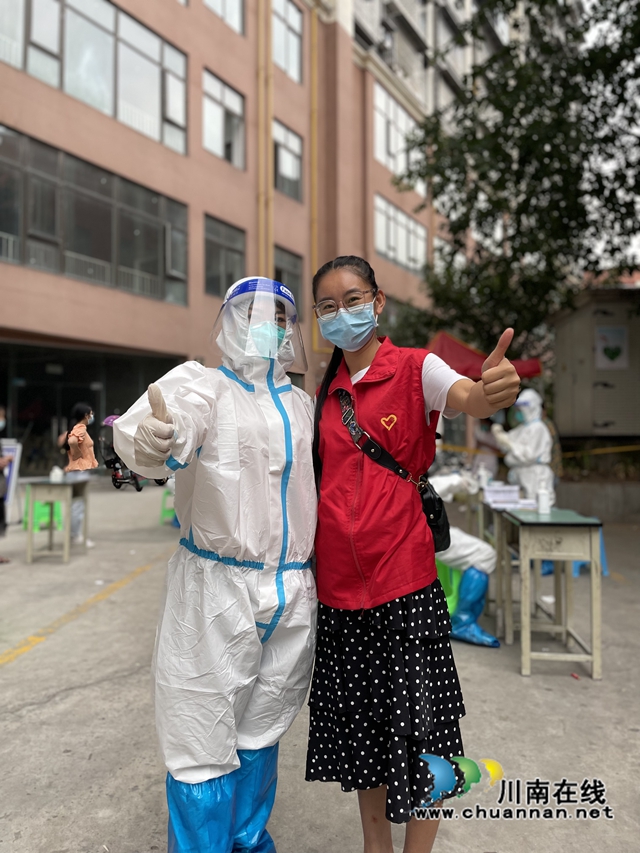 志愿者简国勤（穿红马甲）与核酸检测人员合影.jpg