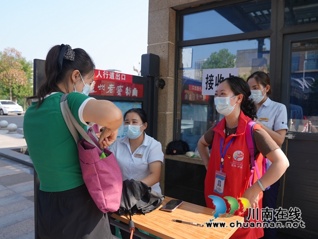 泸县党员志愿者详细询问记录小区居民的出行台账.JPG