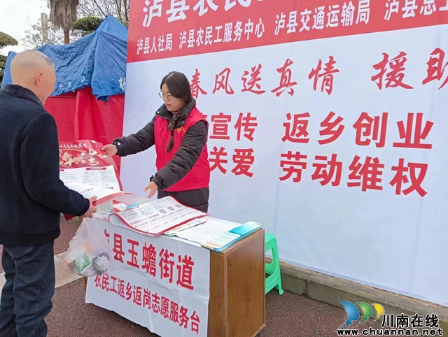 志愿者向返乡农民工发放宣传资料（张懿摄）.jpg