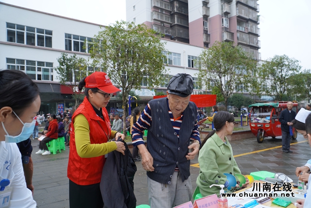 泸县：公益志愿者温柔之手为测血压老人穿外套