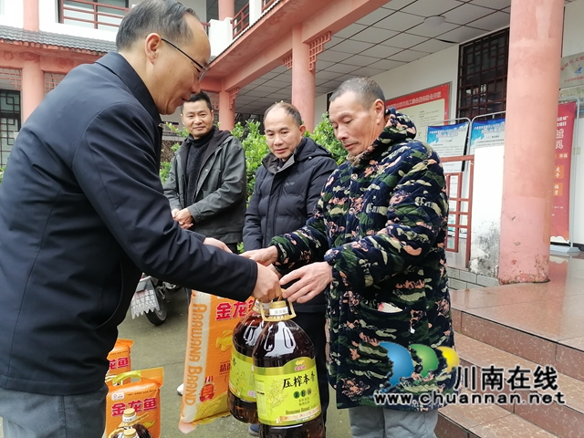 泸县得胜镇便民服务中心主任刘云贵（左一）为农民工留守家人代表送上暖心慰问物品.jpg