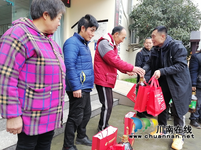 泸县农民工服务中心副主任李雪亮在泸县天兴镇板栗村为农民工留守家人代表送上暖心慰问物品.jpg