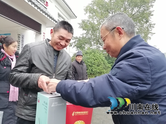 泸县玉蟾街道便民服务中心主任姜树明为龙桥社区返乡农民工代表送上暖心慰问物品.jpg