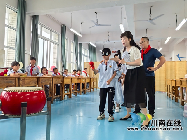 泸县农民工服务中心工作人员带着孩子们玩“敲大鼓”游戏.jpg