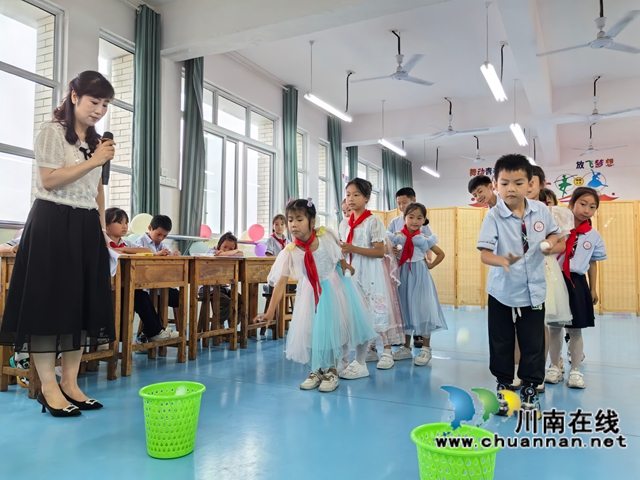 泸县农民工服务中心工作人员带着孩子们玩“投乒乓”游戏.jpg