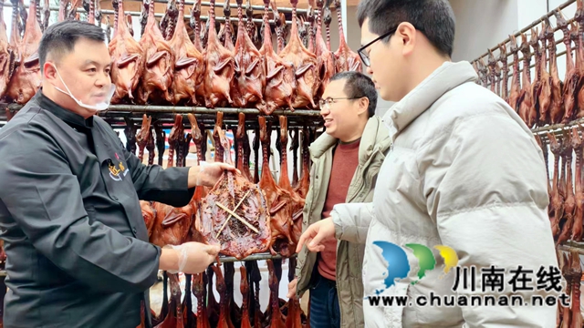 图3：张华国（左一）给客人介绍板鸭制作过程.jpg
